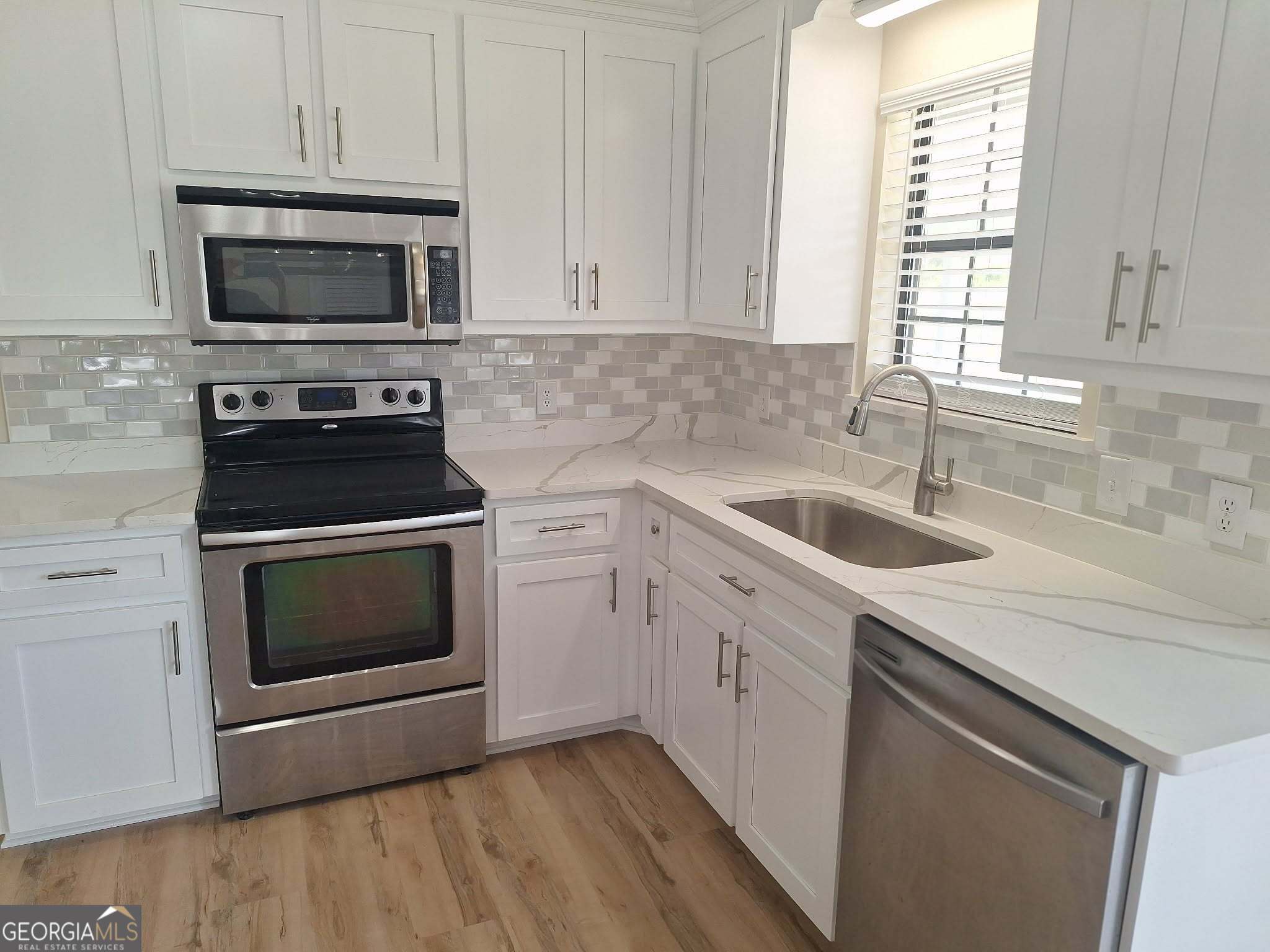 249 Satilla Church Road Baxley, GA 31513 - Photo 4 of 26 a kitchen with white cabinets appliances and sink