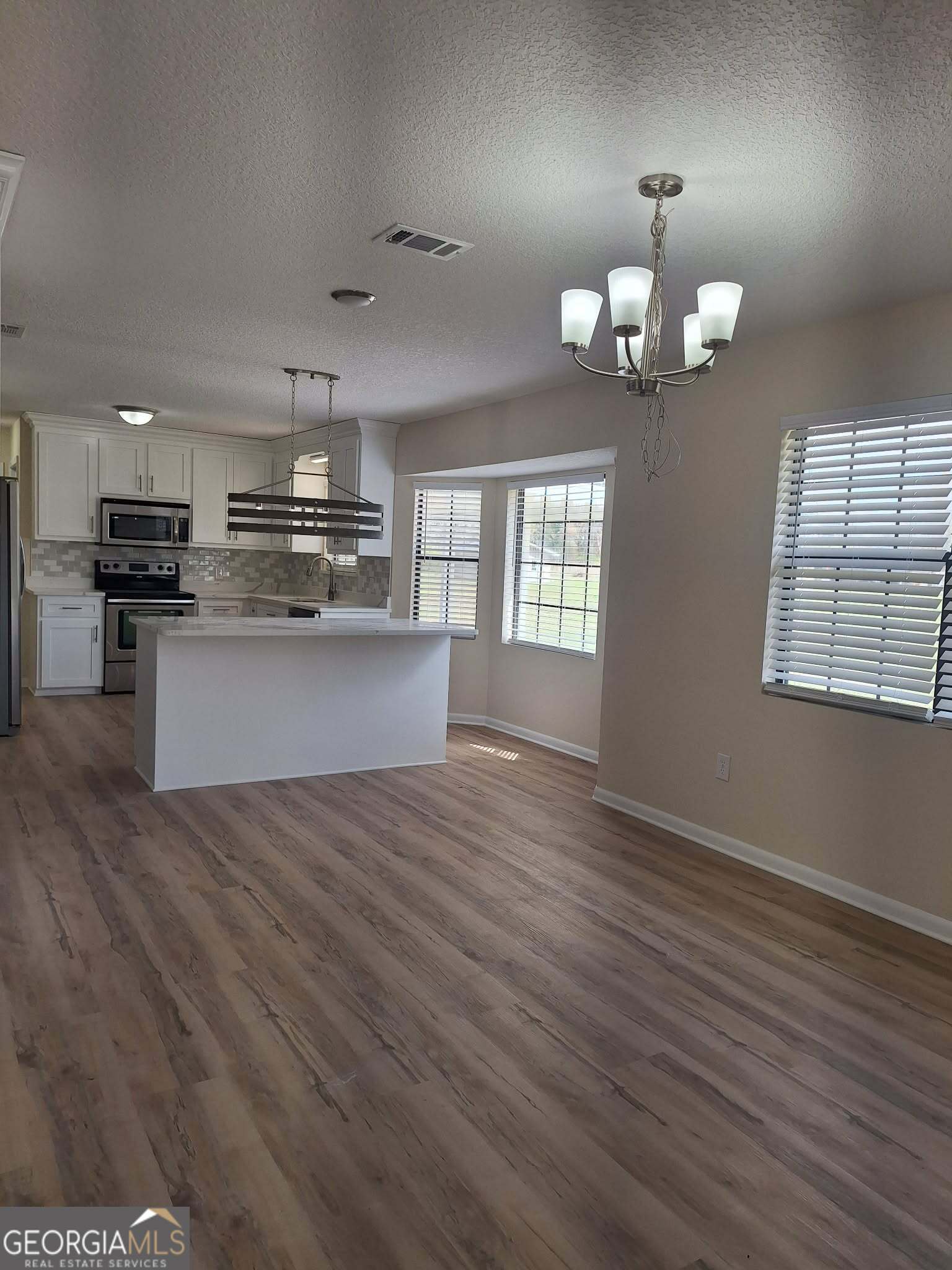 249 Satilla Church Road Baxley, GA 31513 - Photo 6 of 26 a view of a kitchen with a sink wooden floor and chandelier