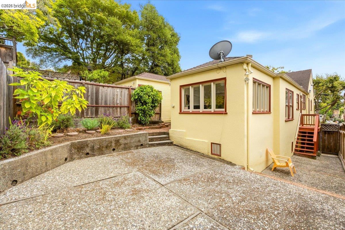 2403 Cedar Street Berkeley, CA 94708 - Photo 18 of 33 Exterior of property featuring a light yellow stucco finish, dark trim windows, and a multi-level concrete patio