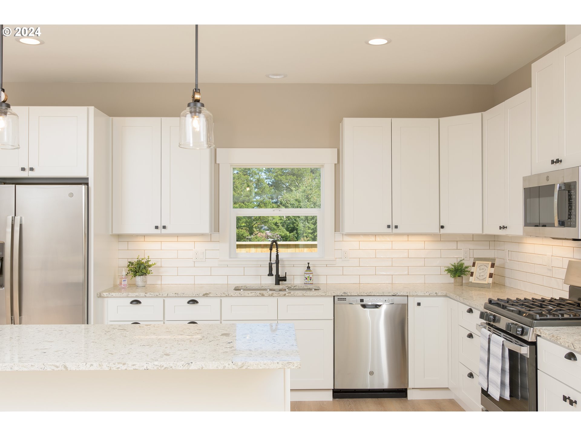 1324 Sea Ridge Lane Gearhart, OR 97138 - Photo 11 of 21 a kitchen with stainless steel appliances white cabinets a sink a stove a refrigerator and white cabinets