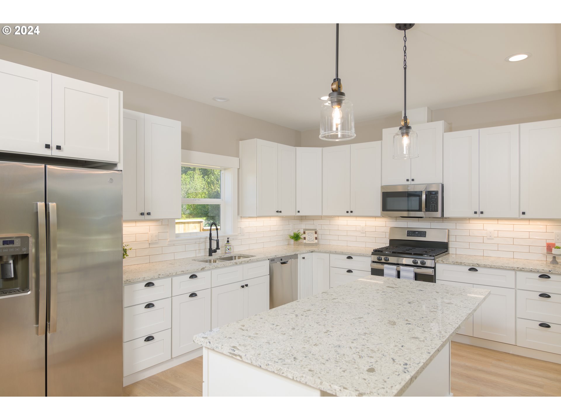 1324 Sea Ridge Lane Gearhart, OR 97138 - Photo 10 of 21 a kitchen with stainless steel appliances kitchen island granite countertop a refrigerator a sink a stove and white cabinets