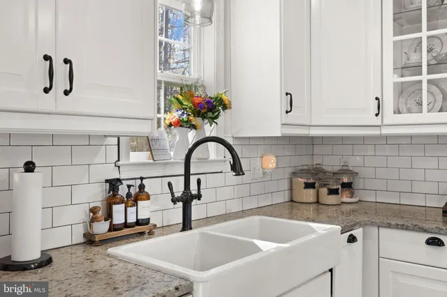 a kitchen with stainless steel appliances granite countertop a sink and a white wooden cabinets