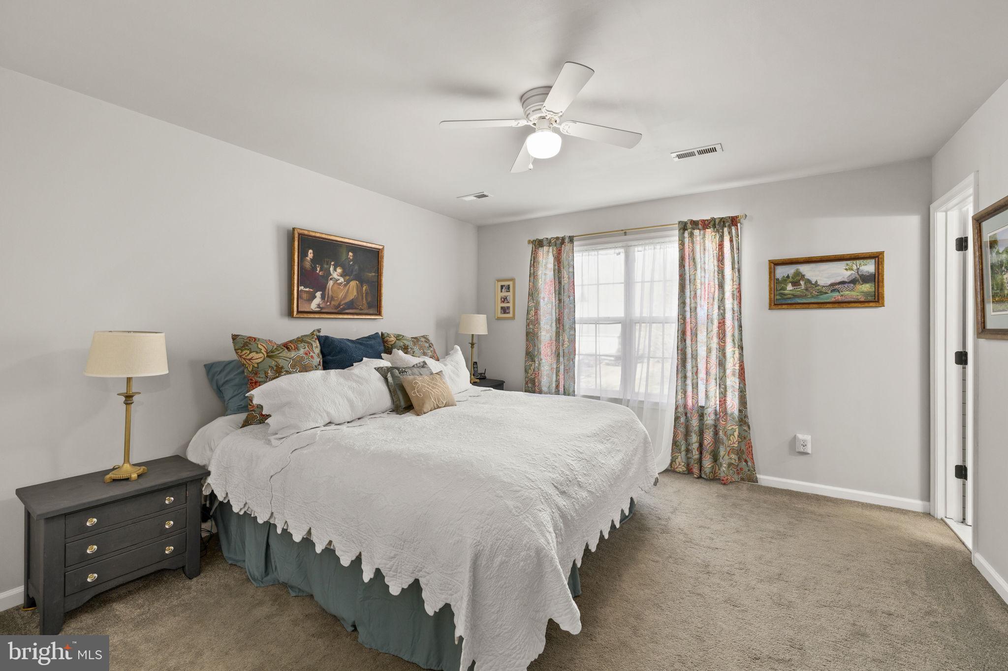 6463 Wheeler Drive King George, VA 22485 - Photo 23 of 57 a spacious bedroom with a bed and a chandelier