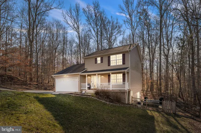 a front view of a house with a yard and lake view