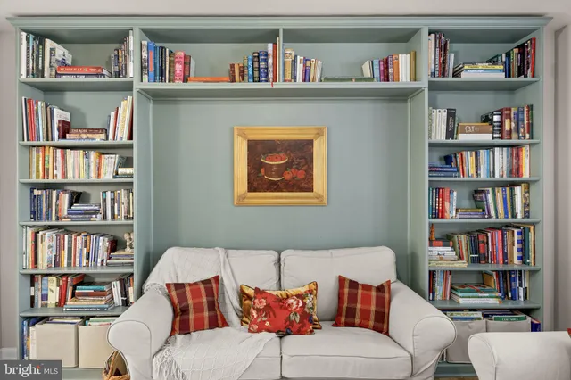 a living room with a book shelf and a book shelf