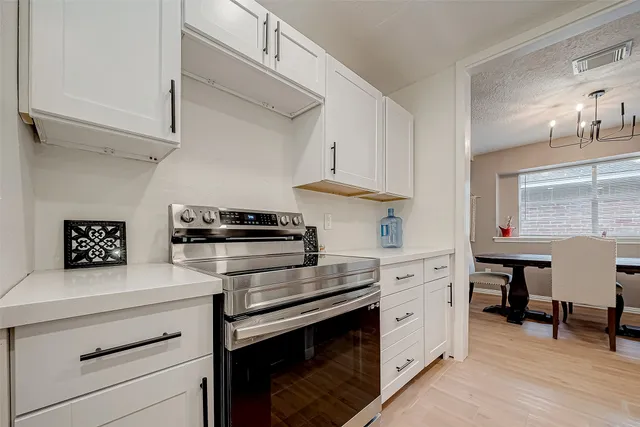 a kitchen with cabinets appliances and a wooden floor