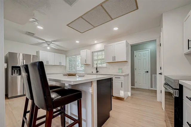 a kitchen with kitchen island a sink stove and refrigerator