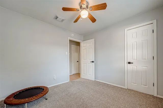 an empty room with closet and a chandelier fan