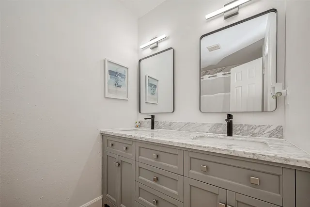 a bathroom with a granite countertop sink vanity and mirror