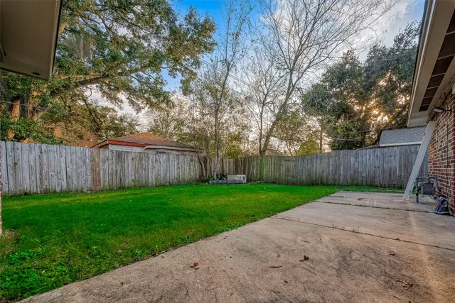a view of a yard with wooden fence