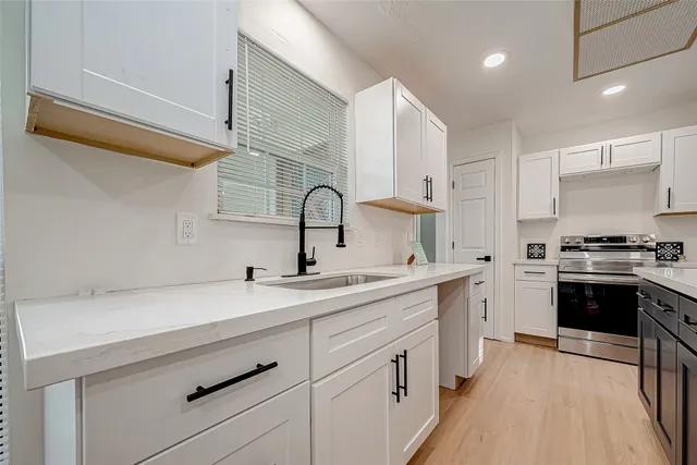 a kitchen with a sink cabinets and stainless steel appliances