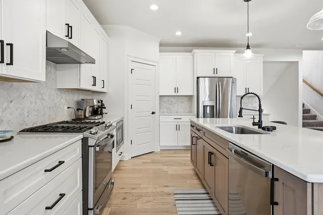 a kitchen with stainless steel appliances granite countertop a sink stove and refrigerator