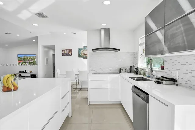 a kitchen with a sink a stove a refrigerator and white cabinets