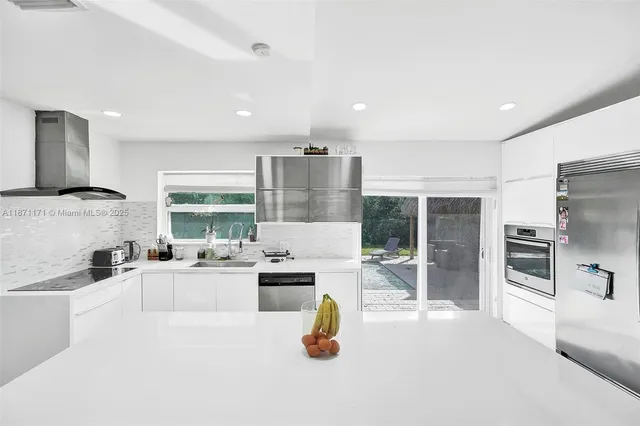 a kitchen with a sink a counter top stainless steel appliances and cabinets