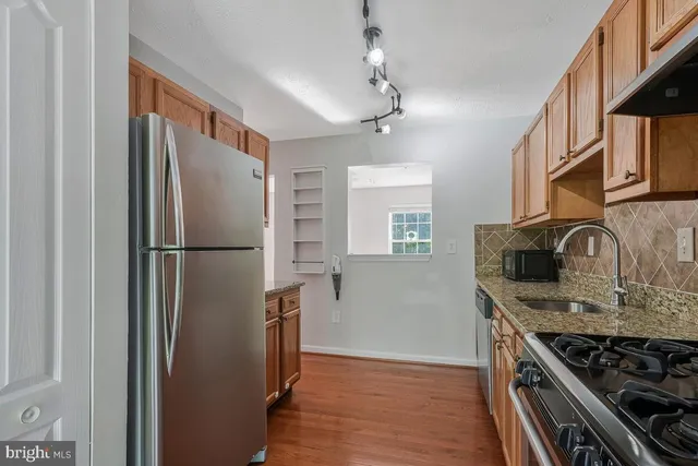 a kitchen with stainless steel appliances granite countertop a refrigerator stove and sink