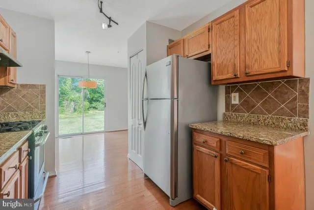 a kitchen with stainless steel appliances granite countertop a refrigerator and a sink