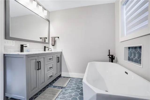 a bathroom with a tub sink and mirror