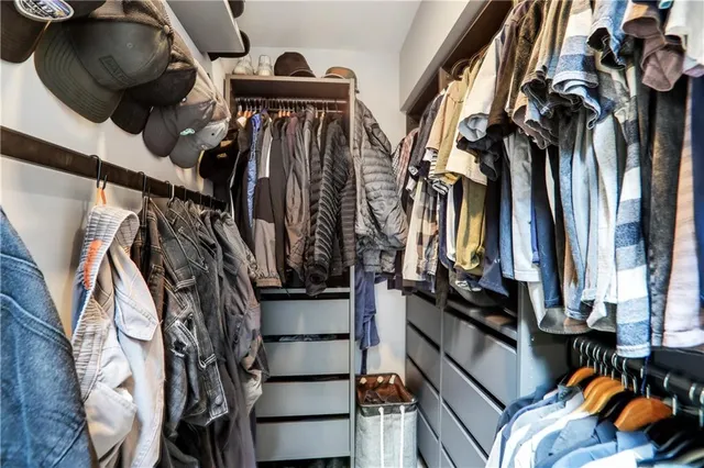a view of walk in closet with clothes and shoes
