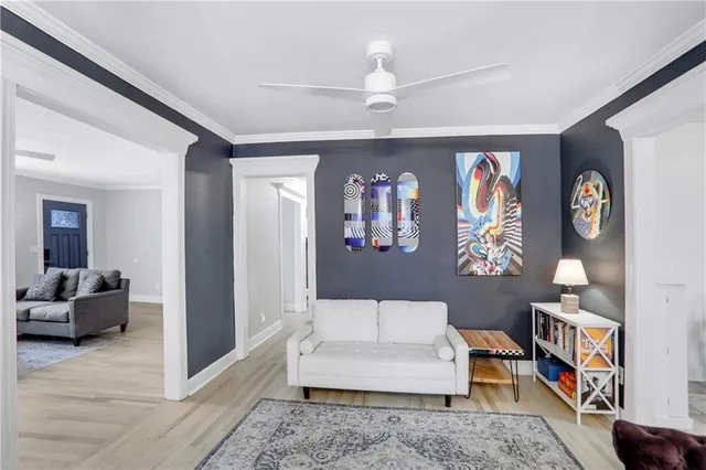 a living room with furniture and paintings on the wall