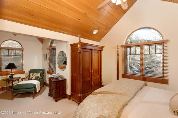 a bedroom with furniture and a large window