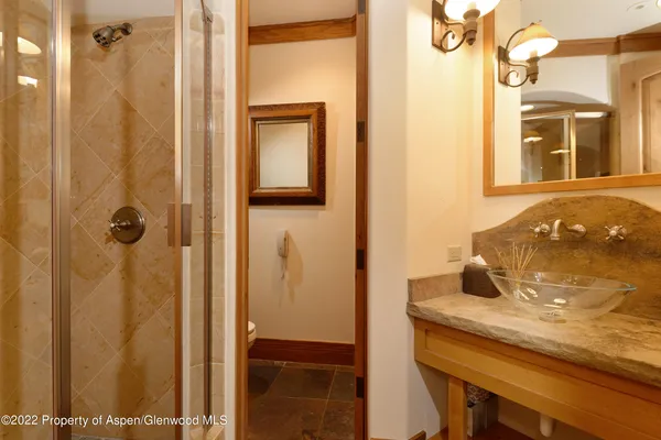 a bathroom with a granite countertop sink and shower