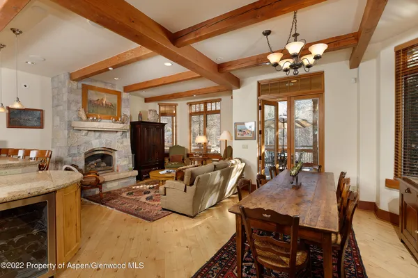 a view of a dining room with furniture a chandelier and wooden floor