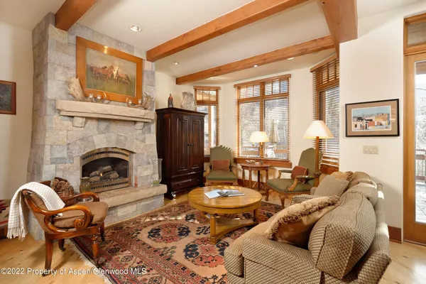 a living room with furniture a fireplace and a large window