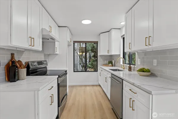 a kitchen with a sink a stove and cabinets