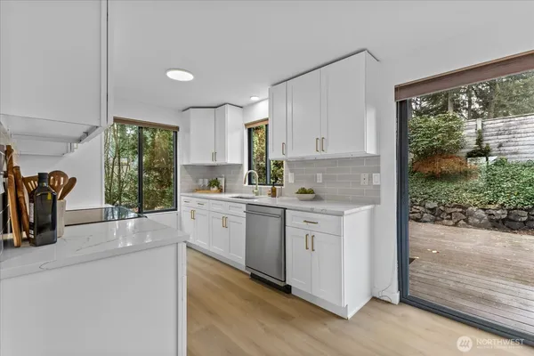a kitchen with granite countertop a stove a sink and a refrigerator