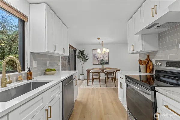 a kitchen with granite countertop a sink stove and cabinets