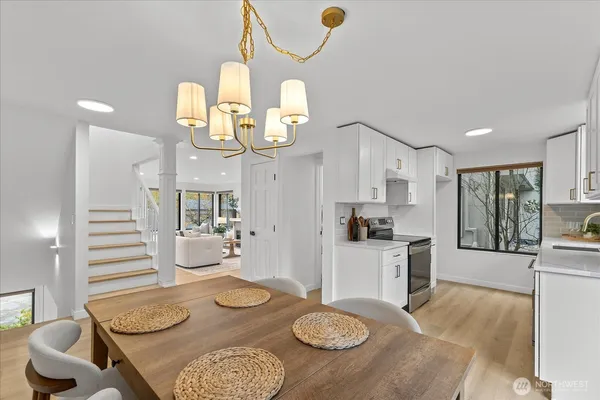 a kitchen with stainless steel appliances kitchen island granite countertop a table and chairs in it
