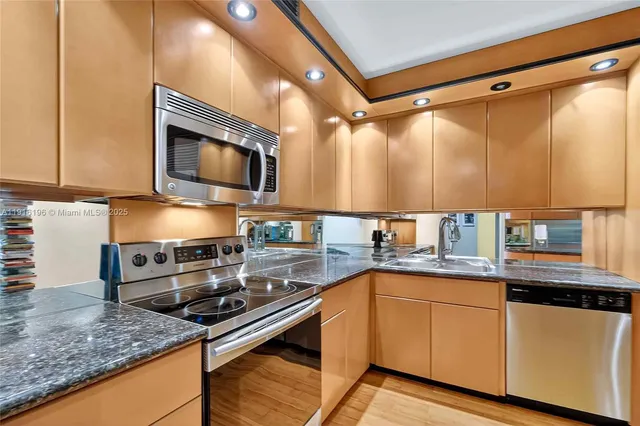 a kitchen with stainless steel appliances granite countertop a sink stove and microwave