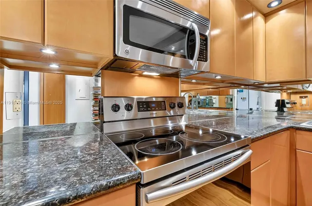 a kitchen with stainless steel appliances granite countertop a sink a stove and oven