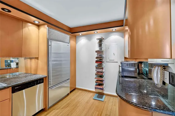 a kitchen with granite countertop a refrigerator and a stove