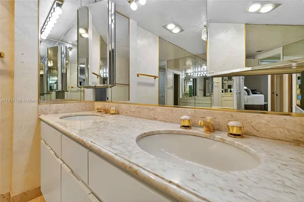a bathroom with a granite countertop sink and a large mirror