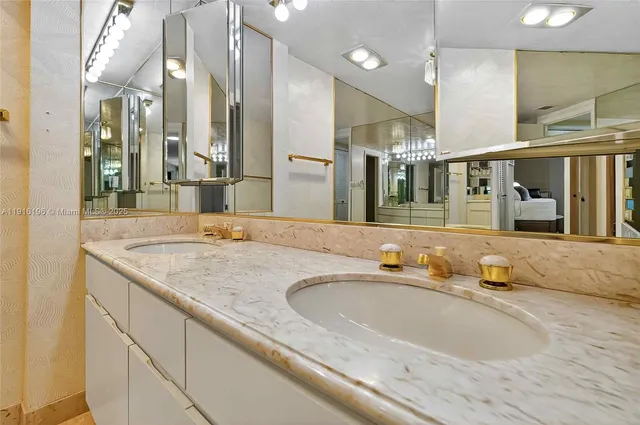 a bathroom with a granite countertop sink and a large mirror