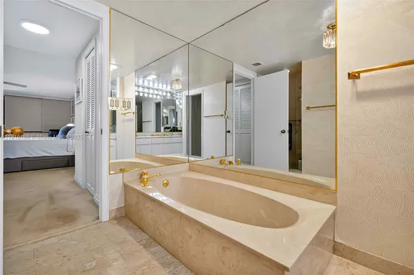a bathroom with a tub a double vanity sink and mirror