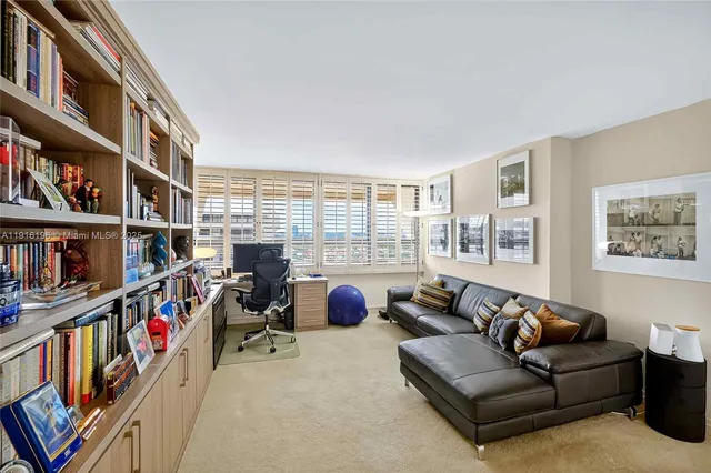 a view of a livingroom with workspace and a window