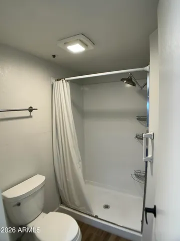 a bathroom with a toilet and a shower