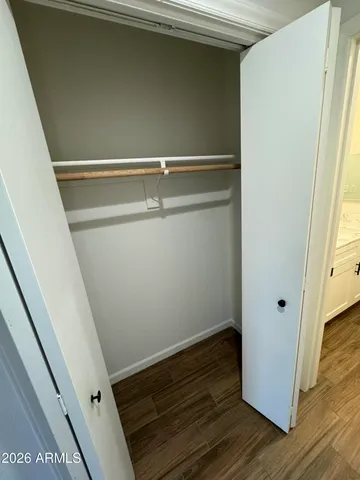 a view of closet with wooden floor