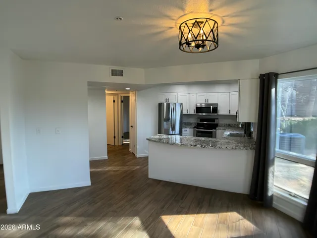 a kitchen with stainless steel appliances granite countertop a refrigerator