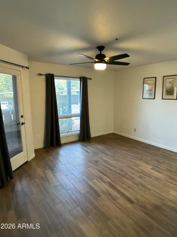 an empty room with wooden floor and windows