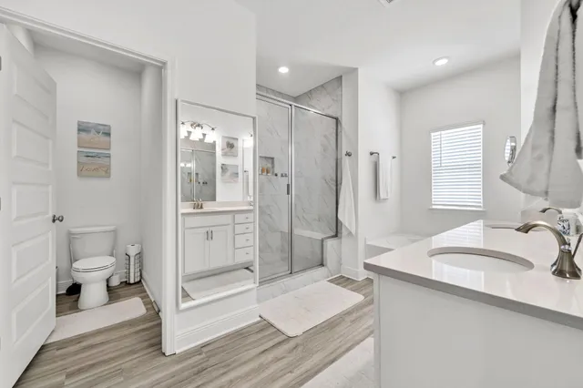 a bathroom with a sink a vanity a mirror and a bathtub with shower