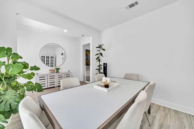 a kitchen with stainless steel appliances granite countertop a refrigerator oven a sink dishwasher and white cabinets with wooden floor