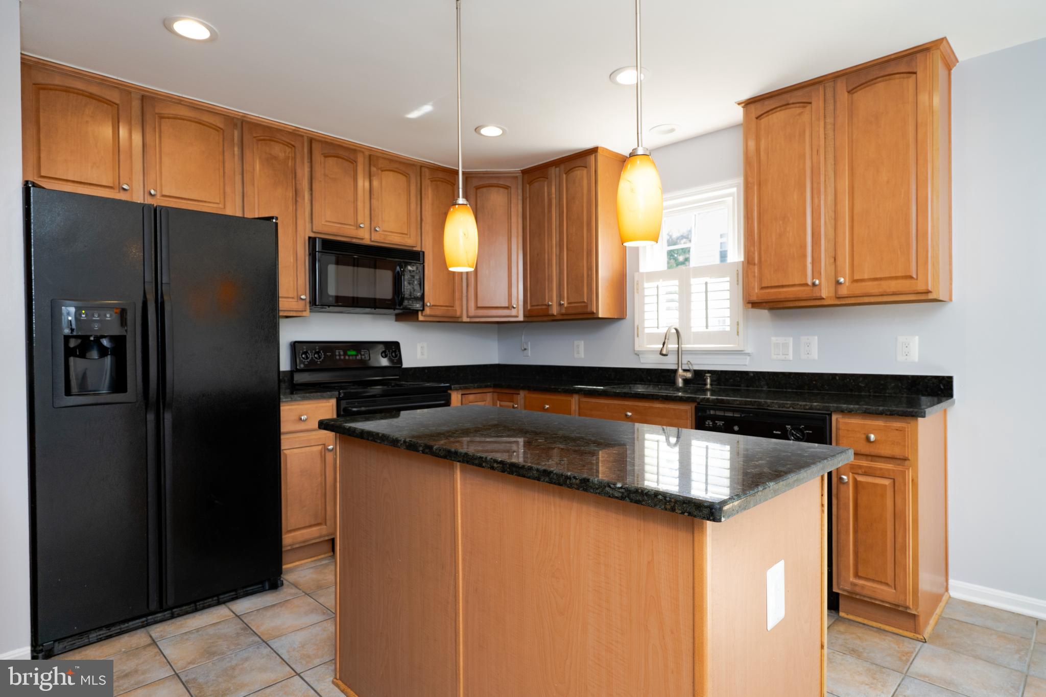 2011 Pieris Court Vienna, VA 22182 - Photo 14 of 39 a kitchen with stainless steel appliances granite countertop a refrigerator a sink a stove a microwave and wooden cabinets