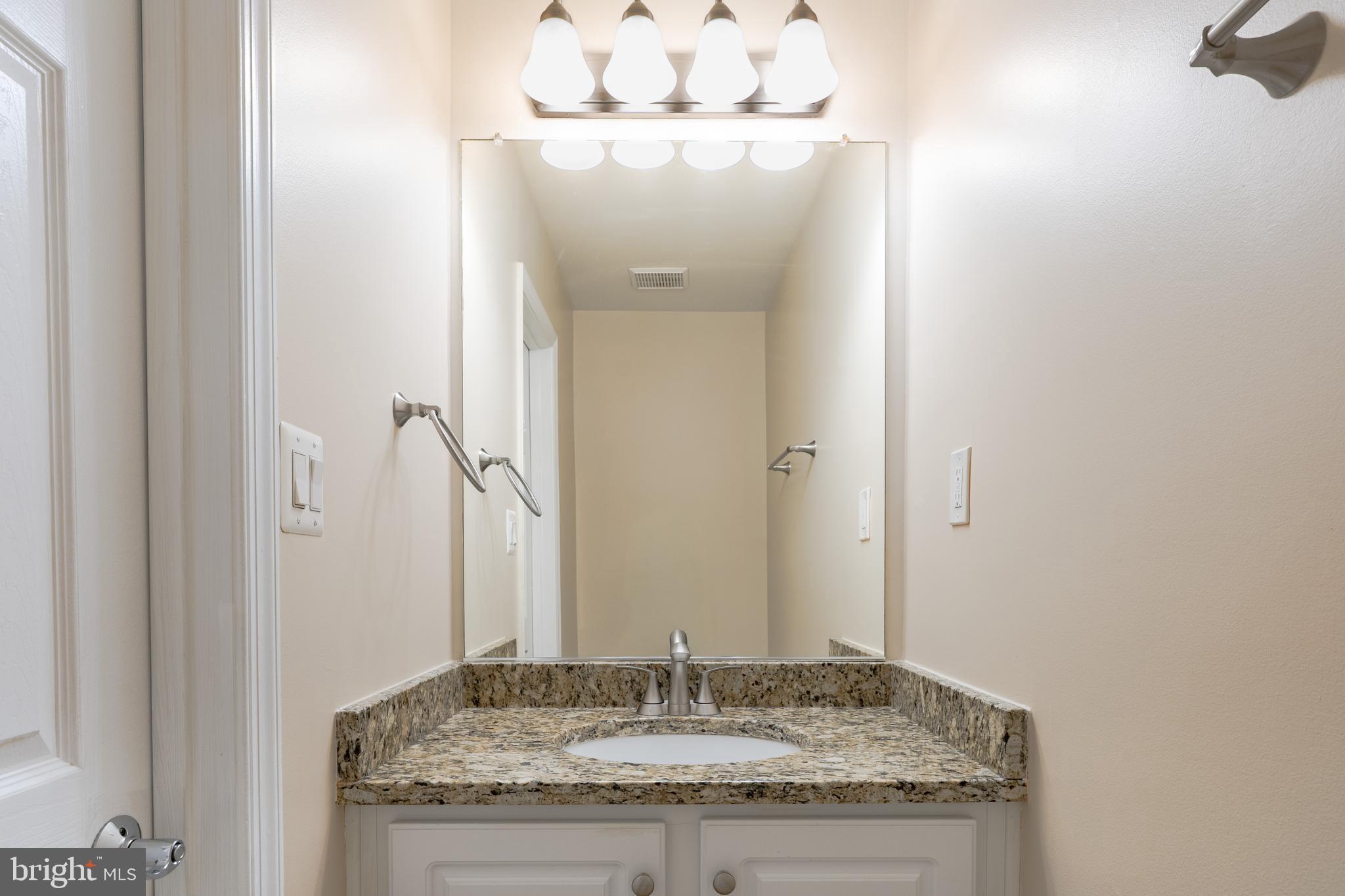 2011 Pieris Court Vienna, VA 22182 - Photo 20 of 39 a bathroom with a granite countertop sink and a mirror