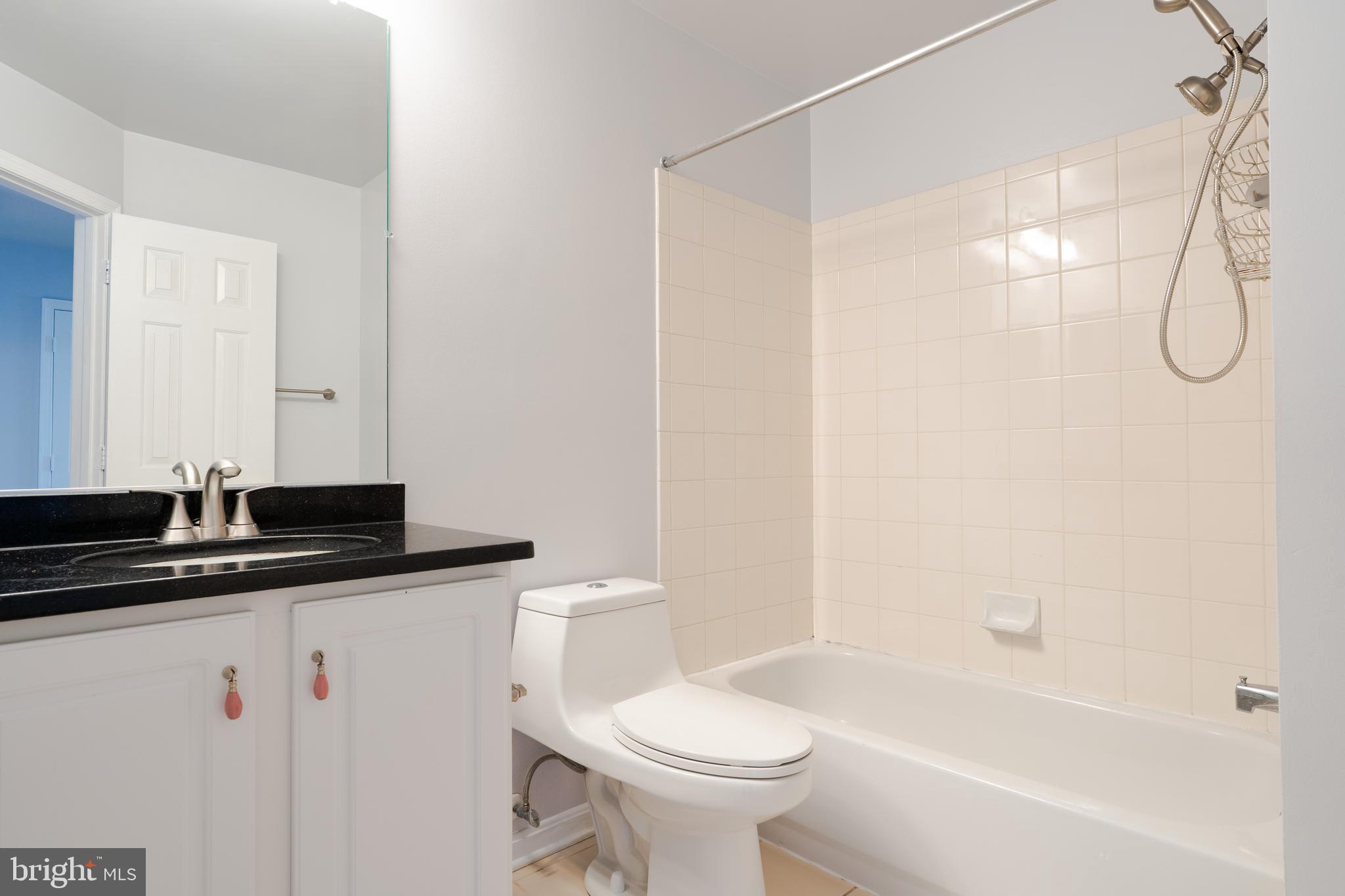 2011 Pieris Court Vienna, VA 22182 - Photo 26 of 39 a bathroom with a granite countertop sink a toilet and a bathtub