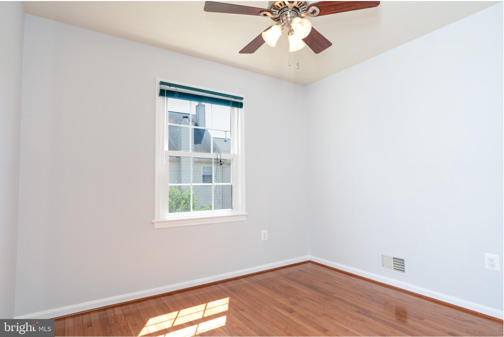 2011 Pieris Court Vienna, VA 22182 - Photo 27 of 39 an empty room with wooden floor chandelier fan and windows