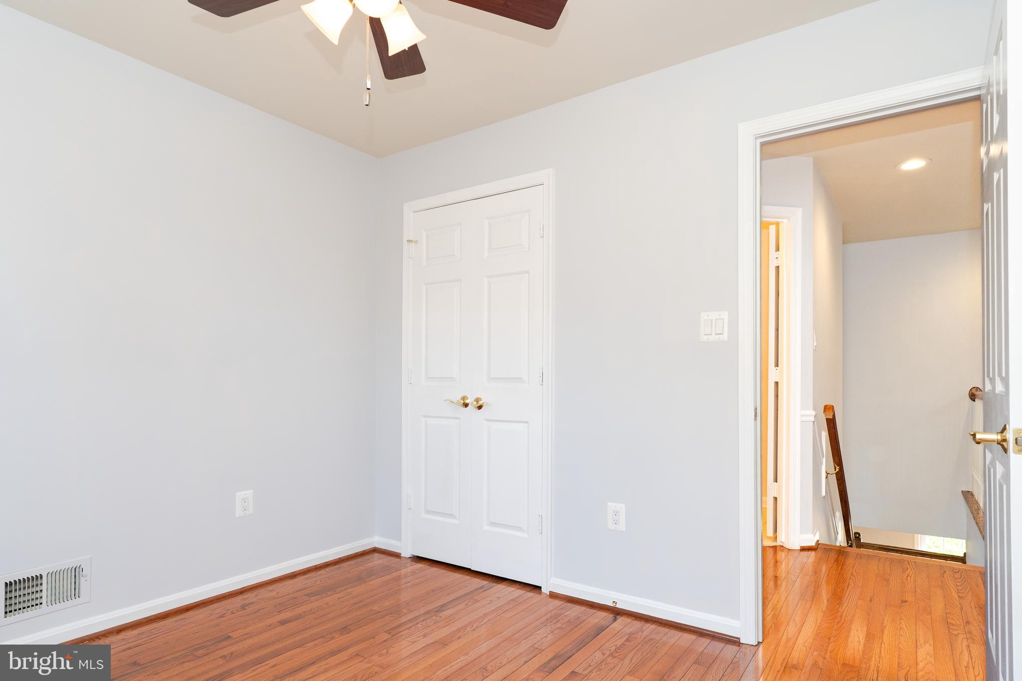2011 Pieris Court Vienna, VA 22182 - Photo 28 of 39 an empty room with wooden floor cabinet and windows