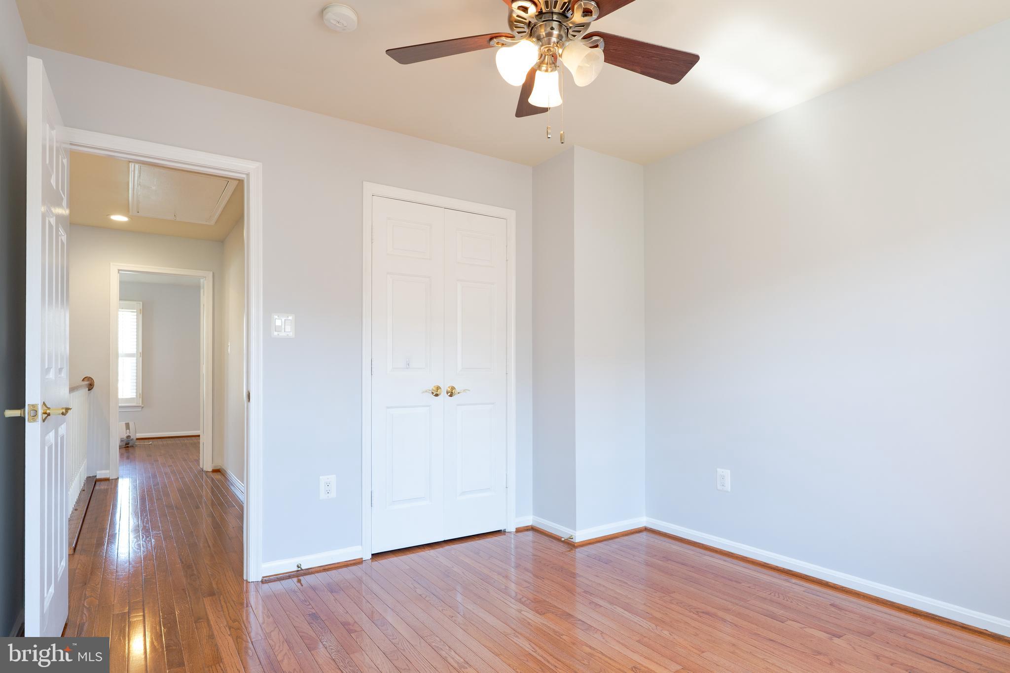 2011 Pieris Court Vienna, VA 22182 - Photo 30 of 39 an empty room with wooden floor and chandelier fan